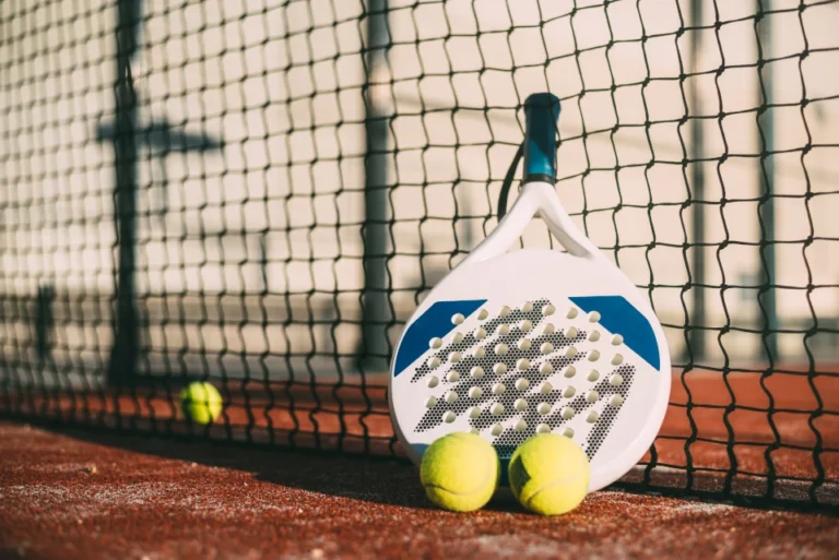 pala de padel que descansa sobre la red
