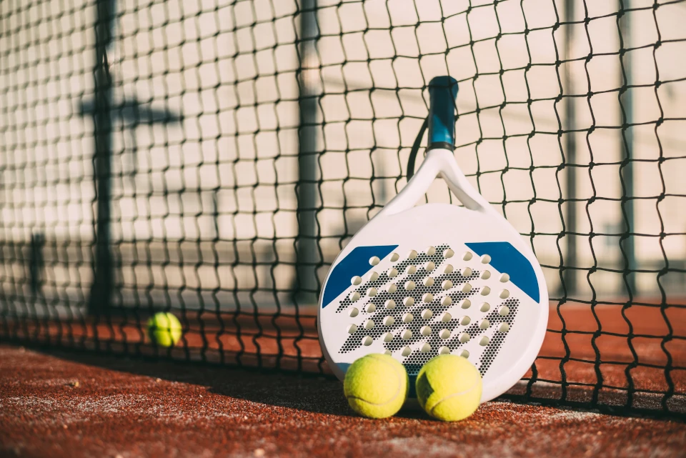 pala de padel que descansa sobre la red